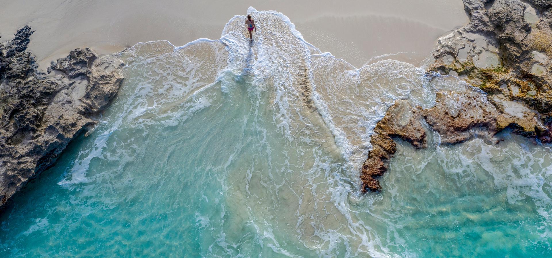 Kobieta spaceruje po plaży Slajd 3